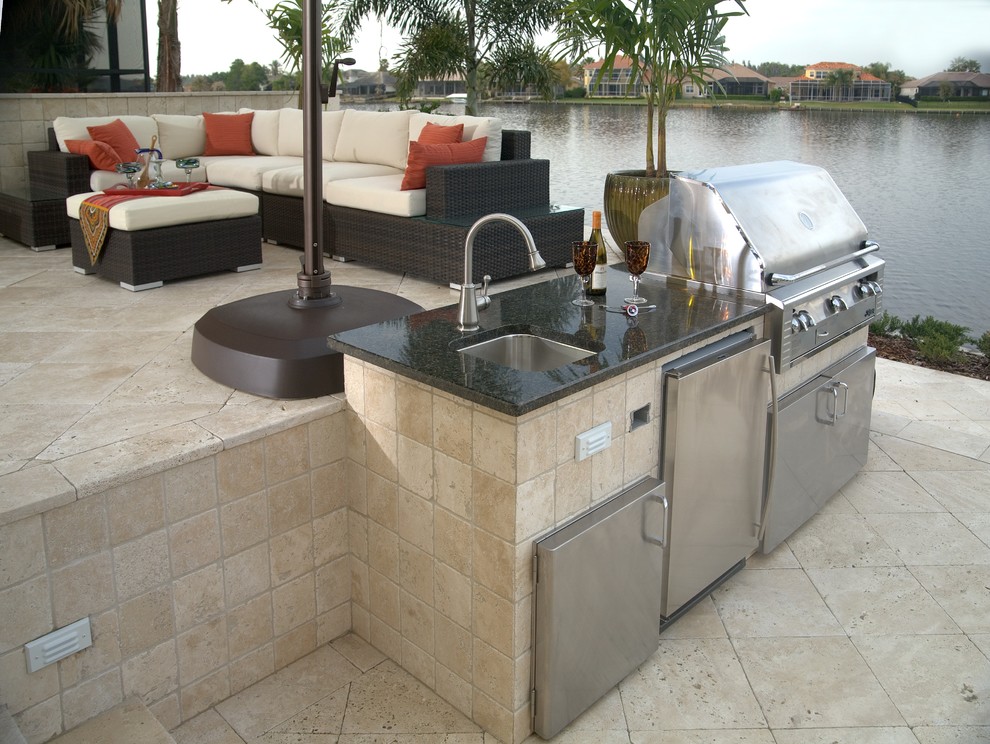 Patio kitchen - mid-sized contemporary backyard stone patio kitchen idea in Tampa