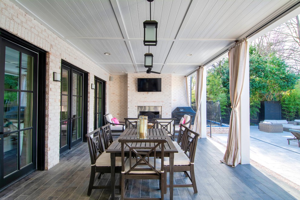 Traditional patio in Charlotte with a fireplace, tiled flooring and a roof extension.