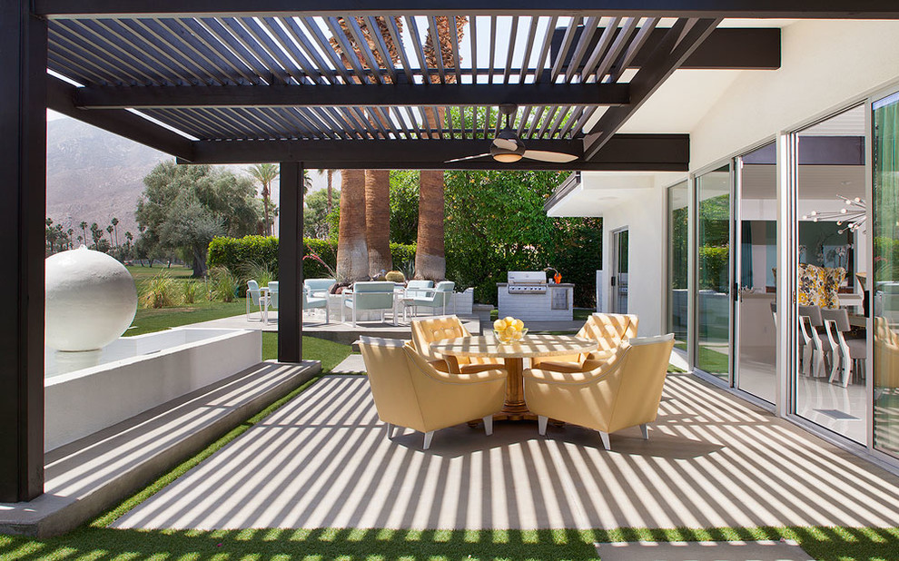 Large midcentury backyard patio in Los Angeles with a pergola, a fire feature and concrete slab.