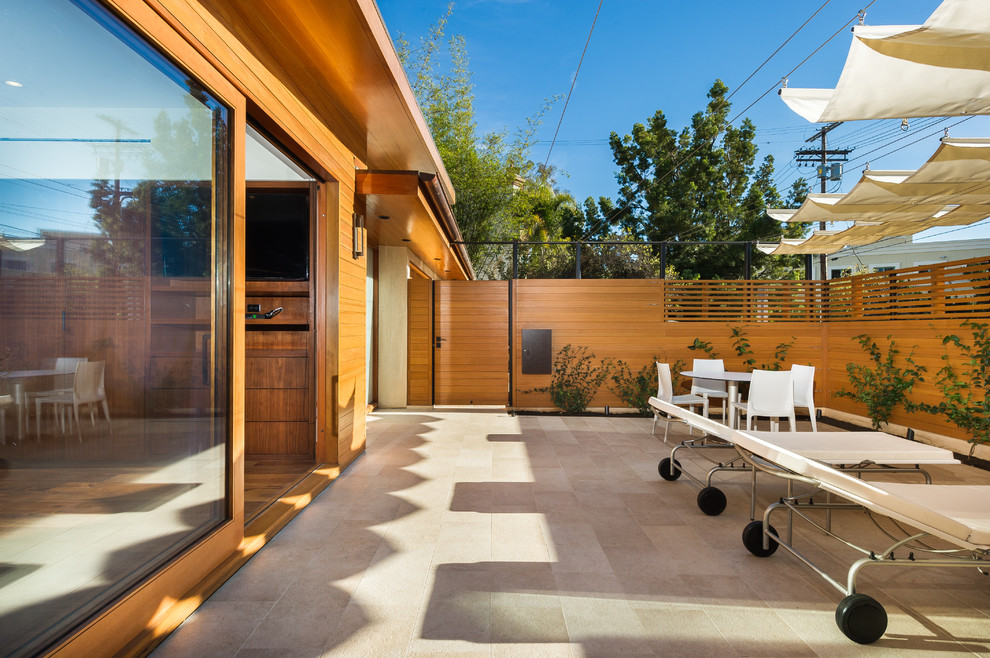 Источник вдохновения для домашнего уюта: двор среднего размера на переднем дворе в стиле модернизм с покрытием из плитки и козырьком