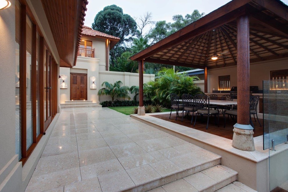 Esempio di un patio o portico etnico di medie dimensioni e dietro casa con pavimentazioni in cemento
