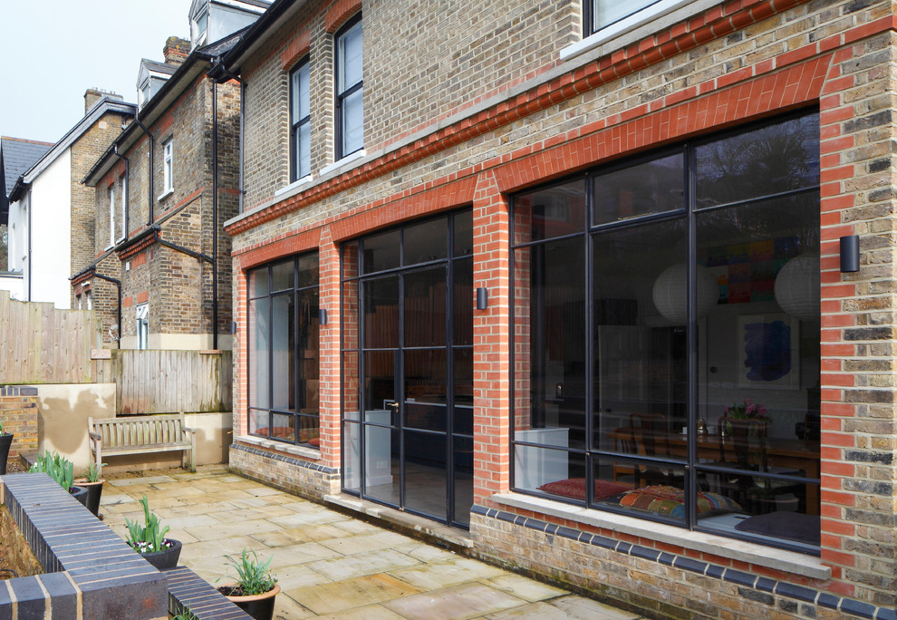 Großer Moderner Patio hinter dem Haus mit Natursteinplatten in London
