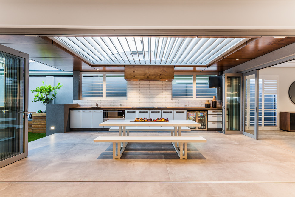 Свежая идея для дизайна: двор в современном стиле с летней кухней, покрытием из бетонных плит и навесом - отличное фото интерьера