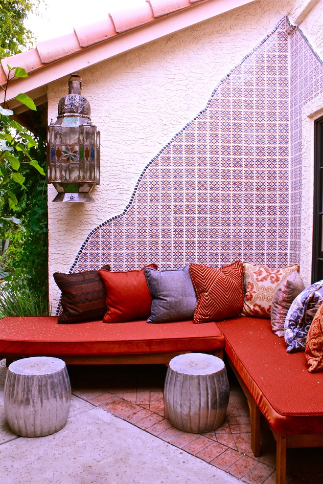 Design ideas for a small bohemian courtyard patio in Phoenix with brick paving and no cover.