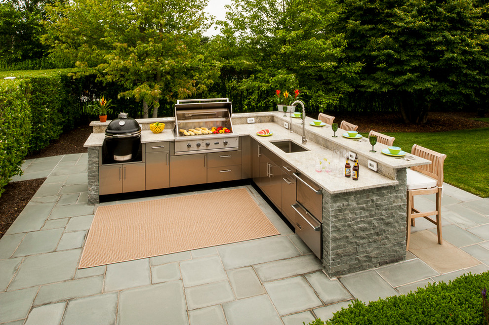Photo of a large classic back patio in New York with an outdoor kitchen, an awning and concrete paving.