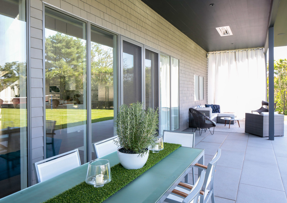 Esempio di un patio o portico minimal di medie dimensioni e dietro casa con un giardino in vaso e un tetto a sbalzo