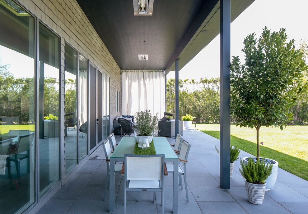Réalisation d'une terrasse avec des plantes en pots arrière design de taille moyenne avec une extension de toiture.