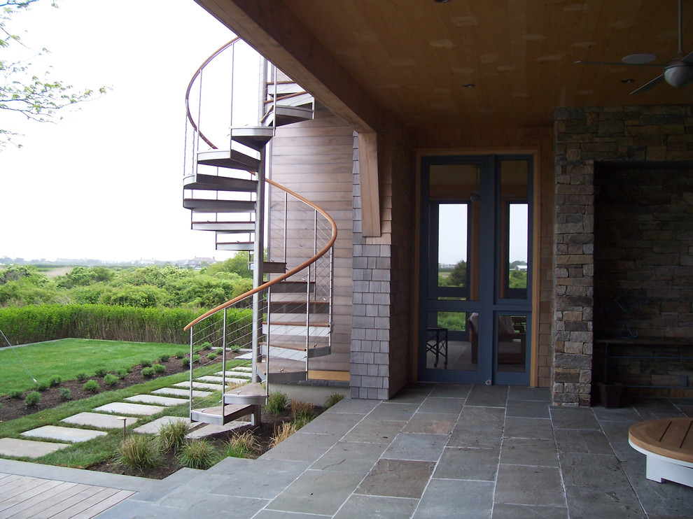 Esempio di un ampio patio o portico stile americano dietro casa con piastrelle e un tetto a sbalzo