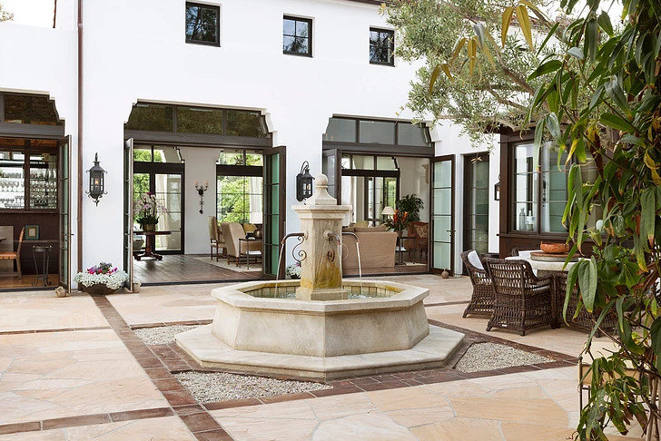 Diseño de patio mediterráneo de tamaño medio sin cubierta en patio con fuente y adoquines de piedra natural