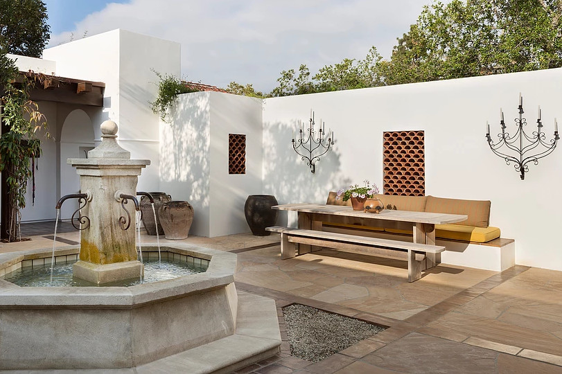 Foto de patio mediterráneo de tamaño medio en patio con fuente y adoquines de piedra natural