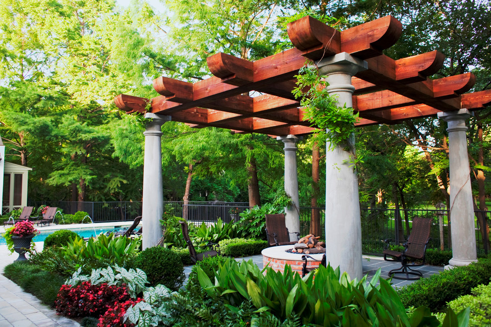 Example of a mid-sized classic backyard stone patio design in Dallas with a fire pit and a pergola