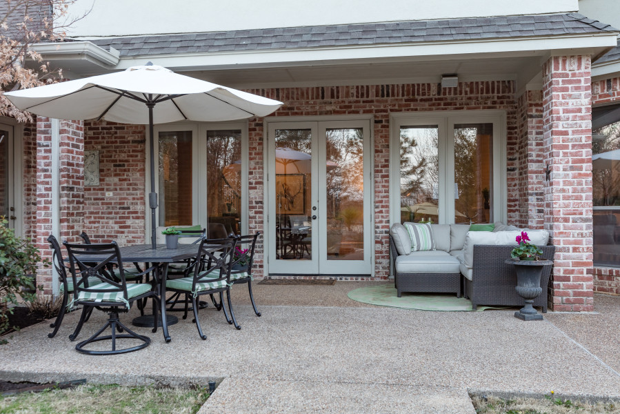 Example of a mid-sized classic backyard concrete paver patio design in Dallas with a roof extension