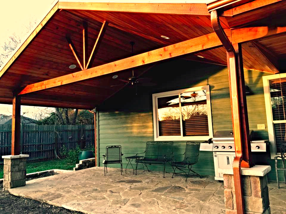 Immagine di un grande patio o portico stile rurale dietro casa con pavimentazioni in pietra naturale e un parasole