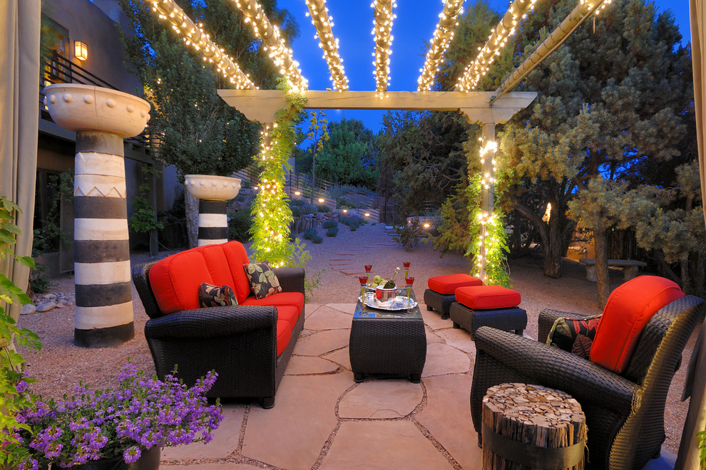 Ejemplo de patio de estilo americano de tamaño medio en patio trasero con adoquines de piedra natural y pérgola
