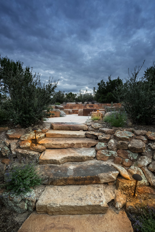 Inspiration for a mid-sized southwestern side yard stone patio remodel in Albuquerque with a fire pit and no cover