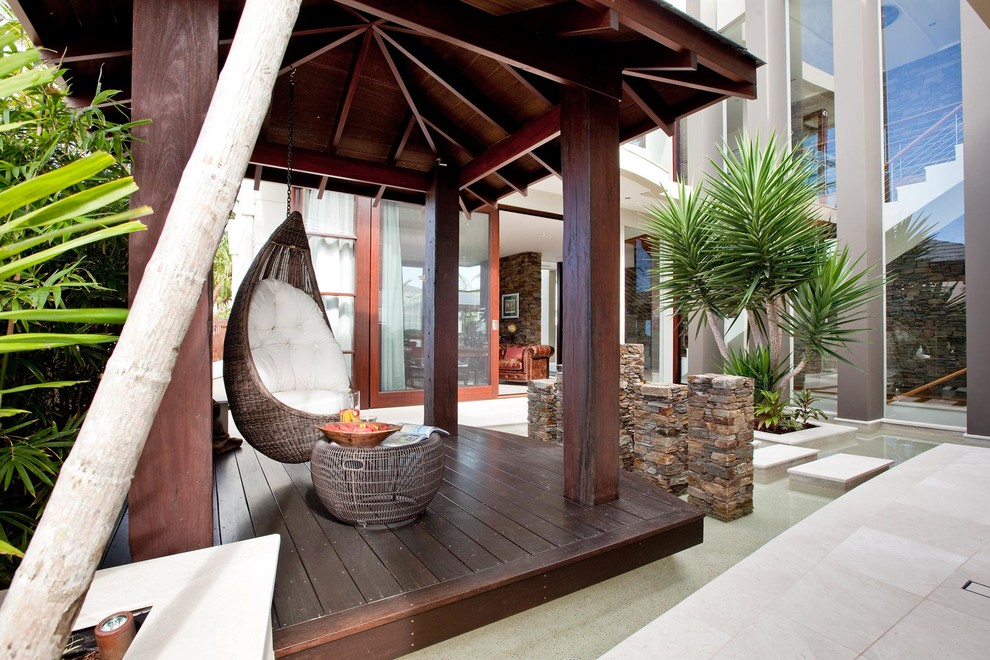 Esempio di un patio o portico tropicale in cortile con fontane e un gazebo o capanno
