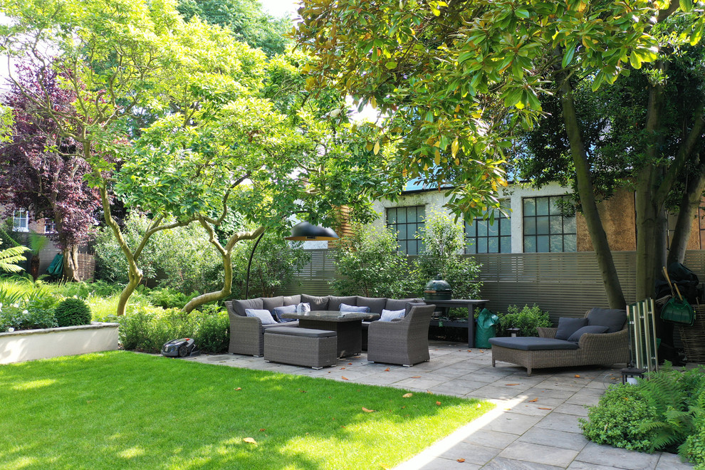 На фото: двор на заднем дворе в стиле неоклассика (современная классика) с покрытием из плитки без защиты от солнца с
