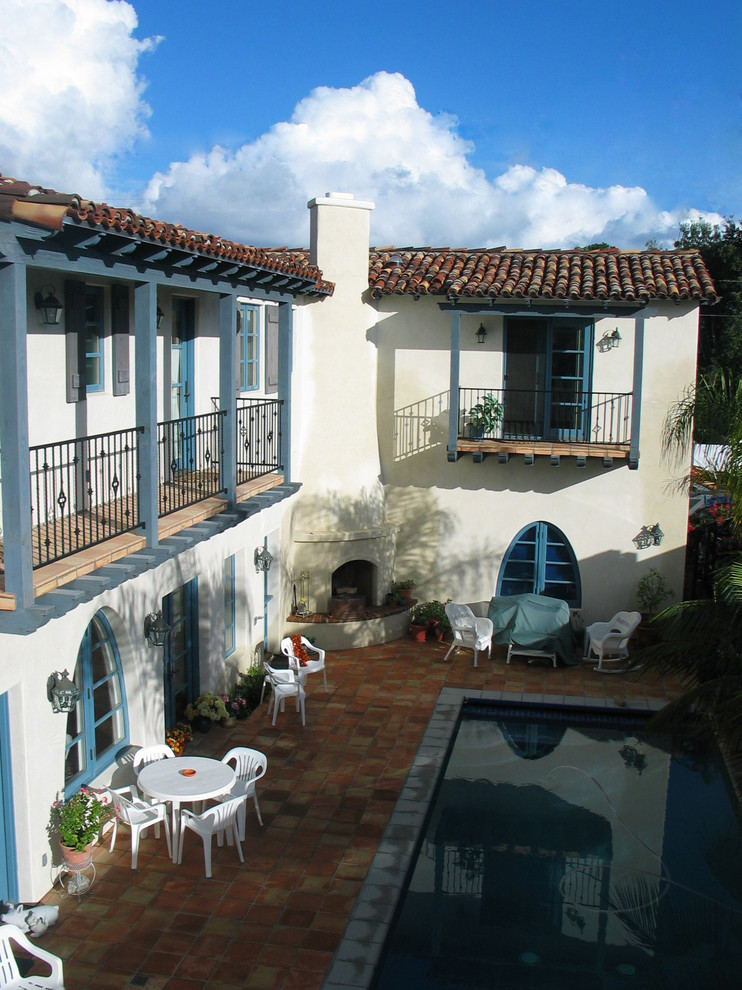 Exemple d'une grande terrasse méditerranéenne avec un foyer extérieur, une cour, des pavés en béton et aucune couverture.