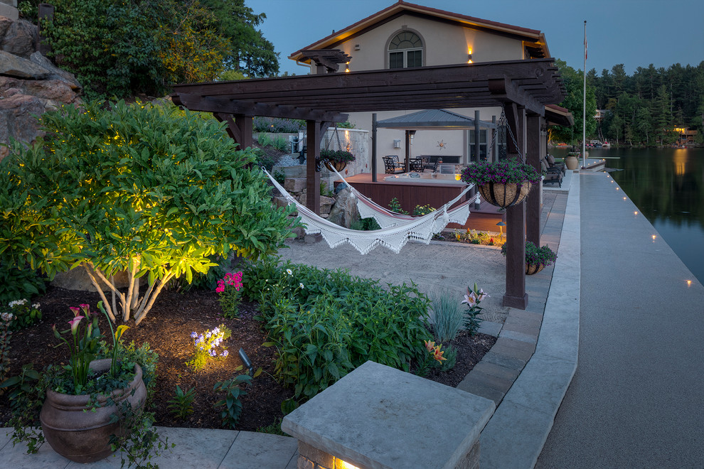 Inspiration for a huge transitional backyard stone patio remodel in Toronto with a pergola