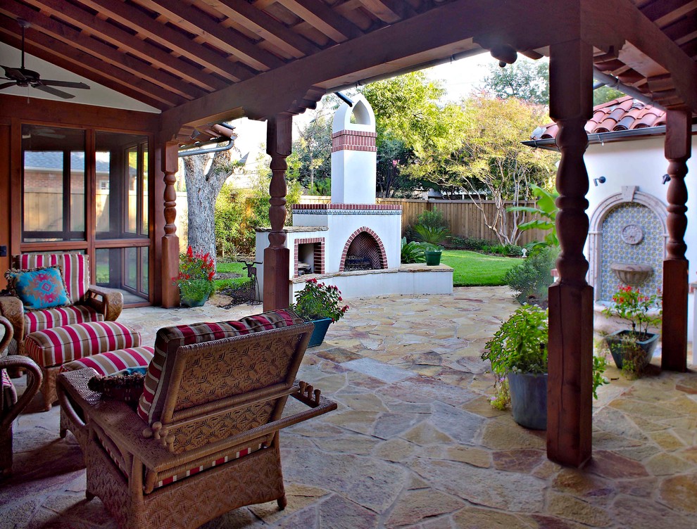 ダラスにある中くらいな地中海スタイルのおしゃれな裏庭のテラス (ファイヤーピット、張り出し屋根、天然石敷き) の写真