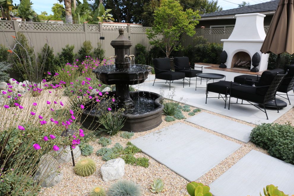 Example of a mid-sized southwest backyard gravel patio fountain design in Portland with no cover