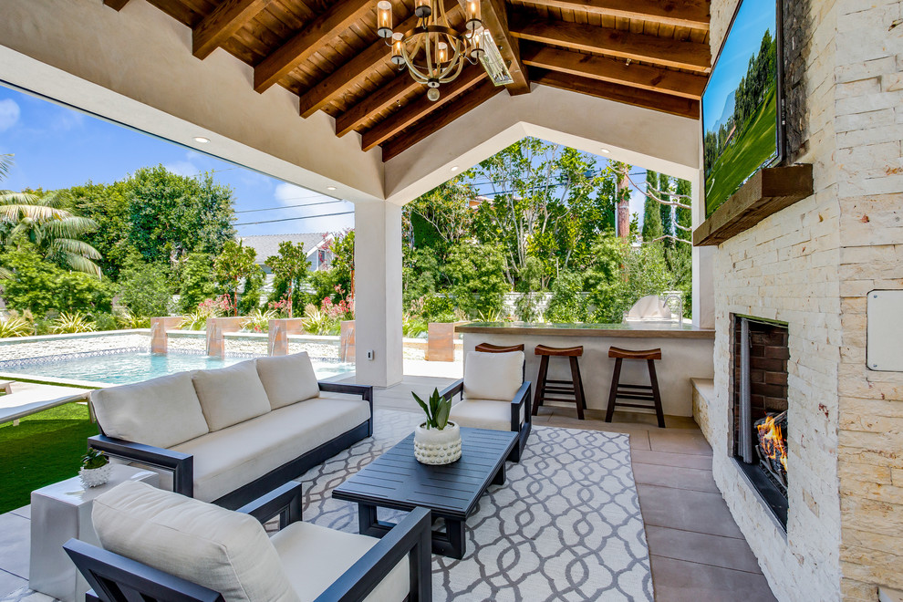Photo of a mediterranean patio in Orange County with a roof extension and a bar area.