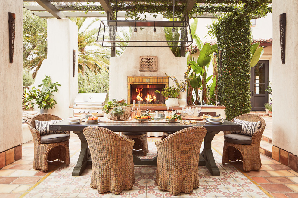 ロサンゼルスにある広い地中海スタイルのおしゃれな中庭のテラス (タイル敷き、パーゴラ、屋外暖炉) の写真