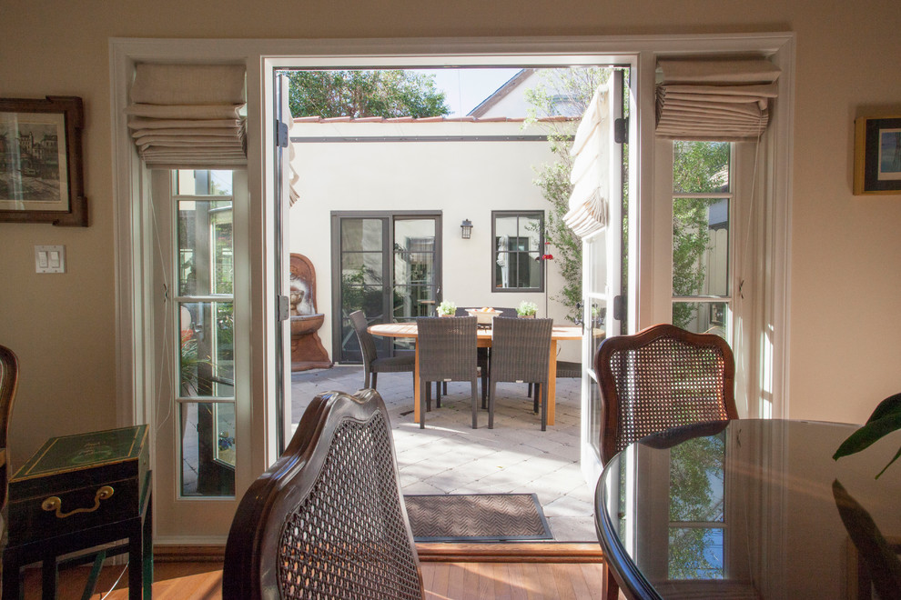 Ejemplo de patio mediterráneo de tamaño medio en patio trasero con cocina exterior, adoquines de piedra natural y toldo