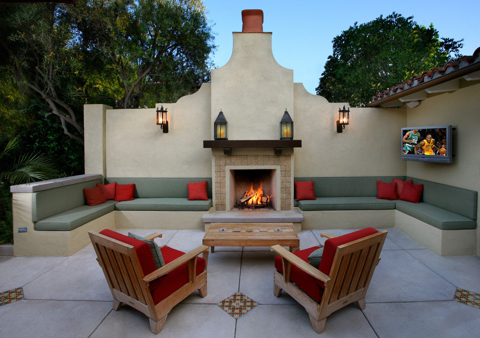 Mediterraner Patio hinter dem Haus mit Feuerstelle und Betonplatten in Los Angeles