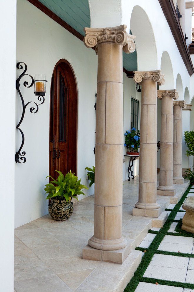 Esempio di un patio o portico mediterraneo in cortile con pavimentazioni in pietra naturale e un tetto a sbalzo