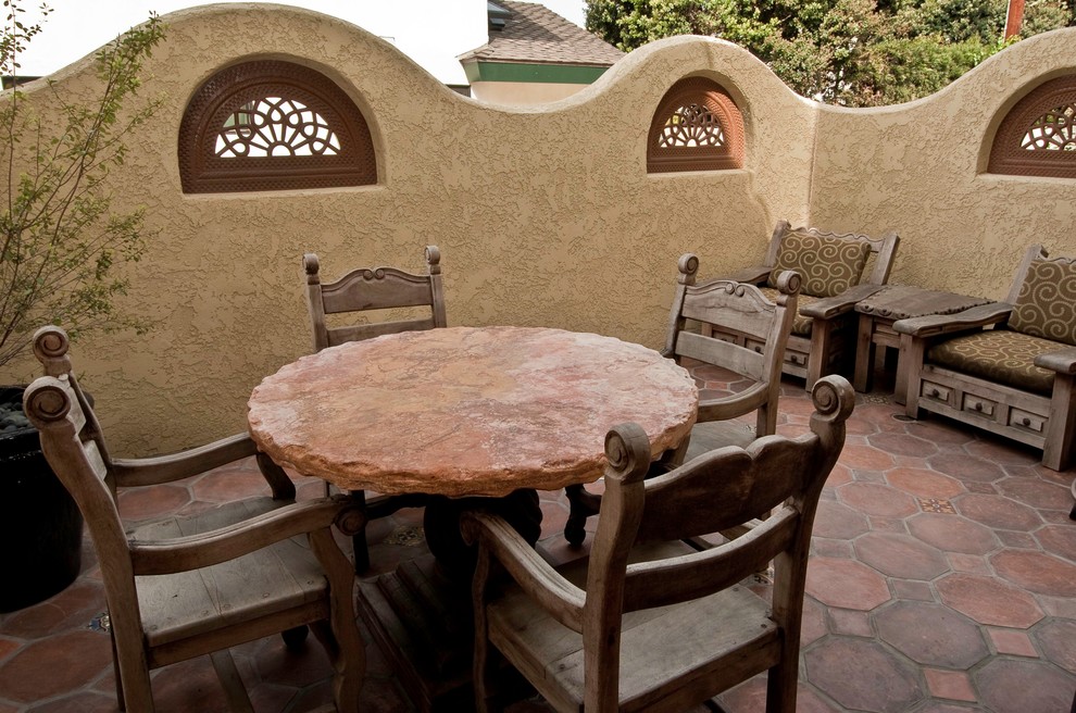 This is an example of a small mediterranean back patio in Los Angeles with an outdoor kitchen, tiled flooring and a roof extension.