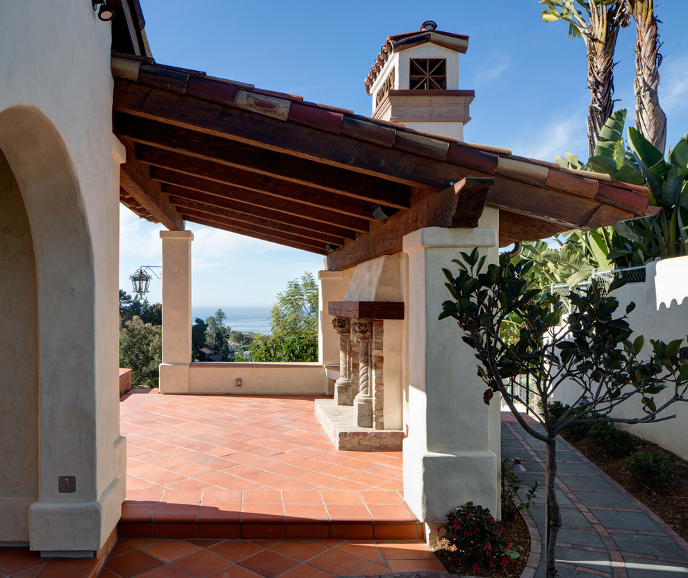 This is an example of a large mediterranean back patio in San Diego with an outdoor kitchen, tiled flooring and no cover.