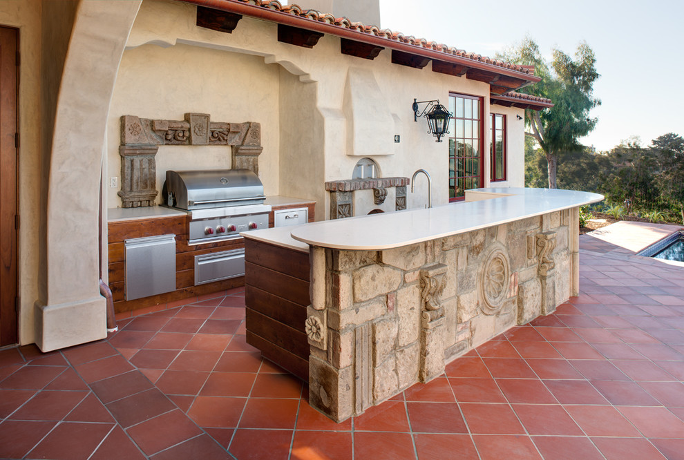 Aménagement d'une grande terrasse arrière méditerranéenne avec une cuisine d'été, du carrelage et aucune couverture.