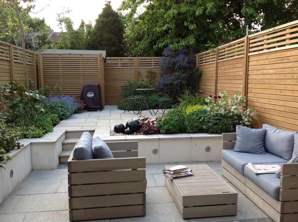 This is an example of a contemporary patio in London with fencing.