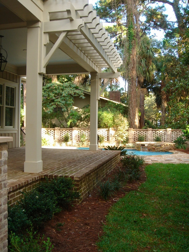 Ispirazione per un grande patio o portico tradizionale dietro casa con pavimentazioni in mattoni e una pergola