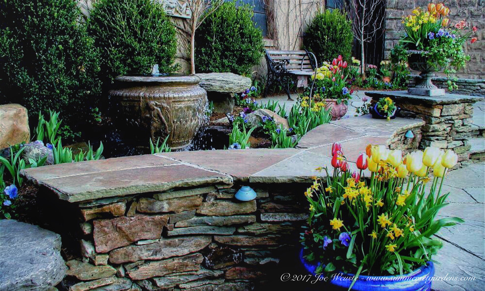 На фото: маленький двор на внутреннем дворе в стиле шебби-шик с растениями в контейнерах и покрытием из каменной брусчатки для на участке и в саду