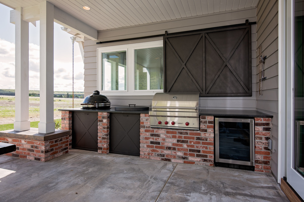 Photo of a rural back patio in Boise with an outdoor kitchen, concrete slabs and a pergola.