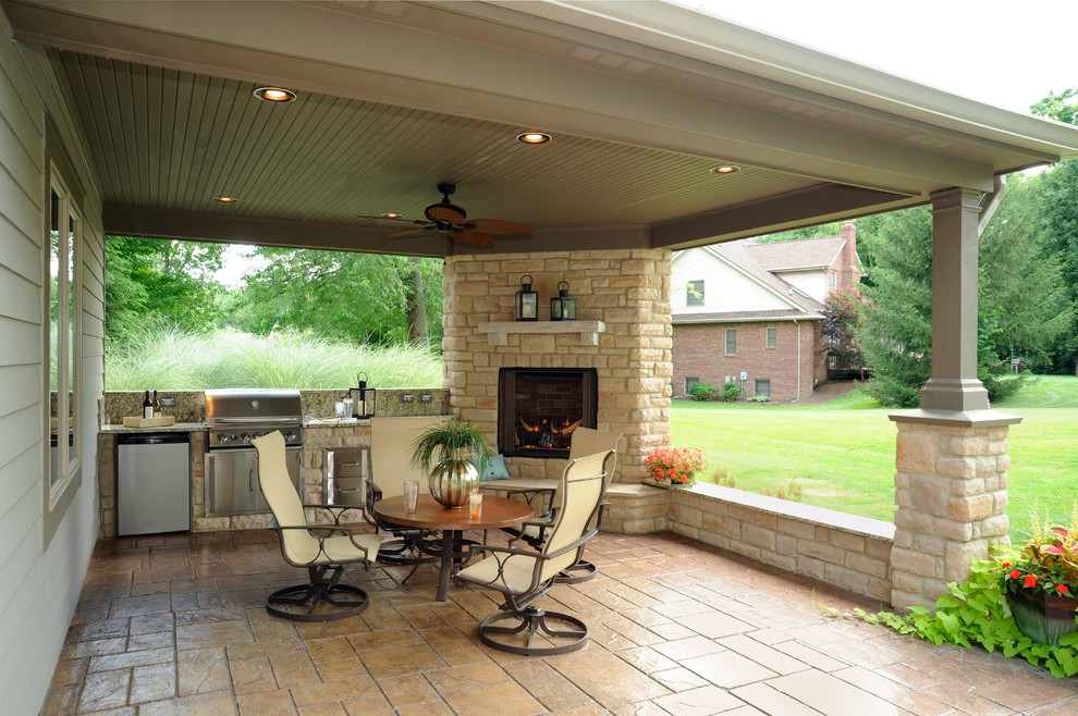 Design ideas for a large traditional back patio in Other with an outdoor kitchen, natural stone paving and a roof extension.