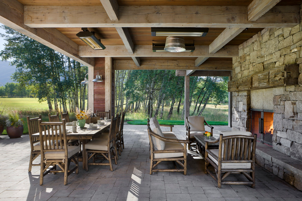 Exemple d'une terrasse nature avec un foyer extérieur et une extension de toiture.