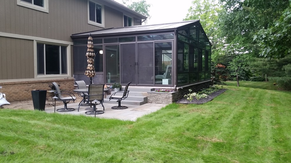 Immagine di un patio o portico classico dietro casa e di medie dimensioni con nessuna copertura, piastrelle e un giardino in vaso