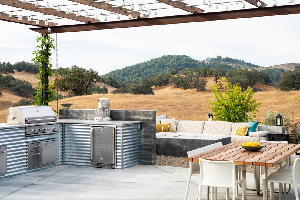 Photo of a farmhouse back patio in San Francisco with concrete slabs, a pergola and a bbq area.
