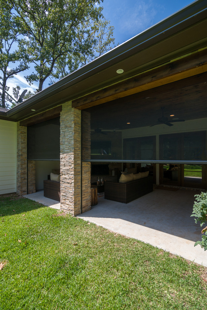 Cette photo montre une terrasse arrière tendance de taille moyenne avec une cuisine d'été, une dalle de béton et une extension de toiture.