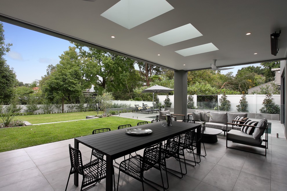 Свежая идея для дизайна: большой двор на заднем дворе в современном стиле с покрытием из каменной брусчатки и навесом - отличное фото интерьера