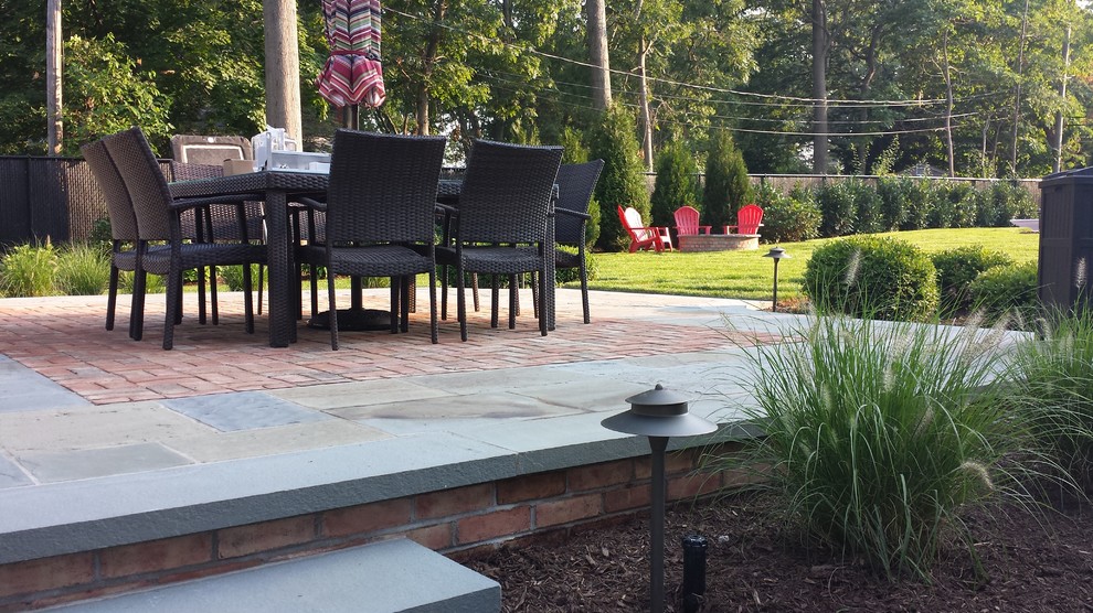 Inspiration for a mid-sized timeless backyard stone patio remodel in Other with no cover