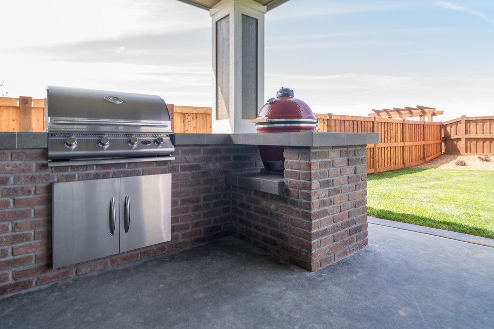 Aménagement d'une terrasse arrière classique de taille moyenne avec une cuisine d'été, une dalle de béton et une extension de toiture.