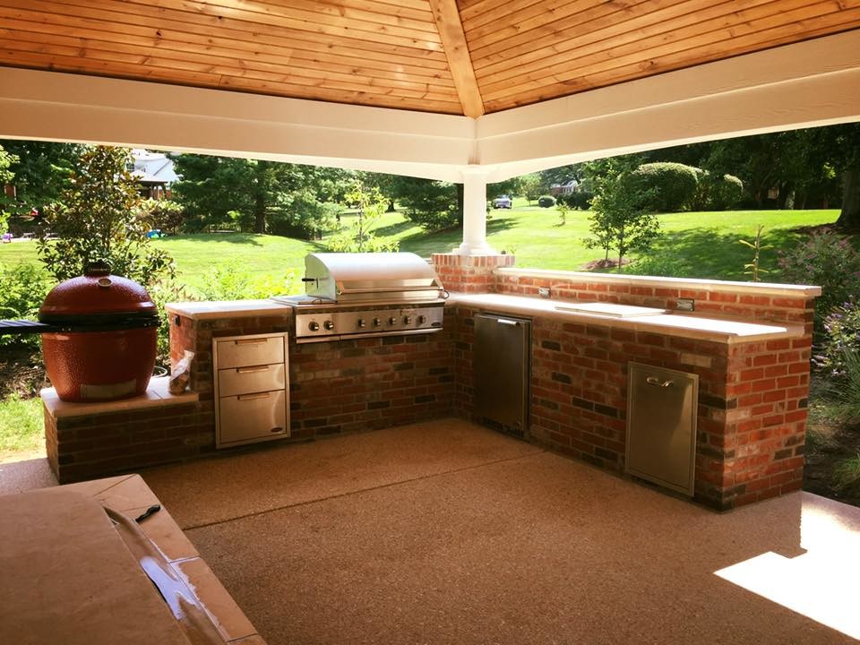 Exemple d'une grande terrasse arrière chic avec une cuisine d'été, une dalle de béton et un gazebo ou pavillon.