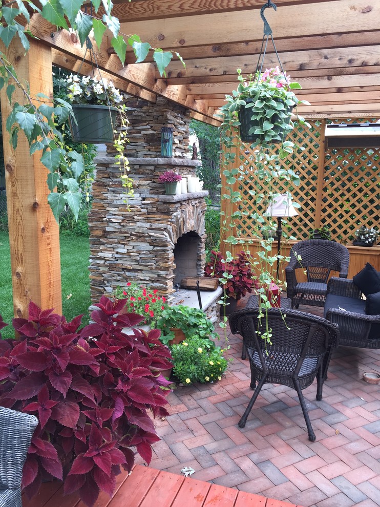 Inspiration for a small backyard brick patio remodel in Minneapolis with a fire pit and a pergola