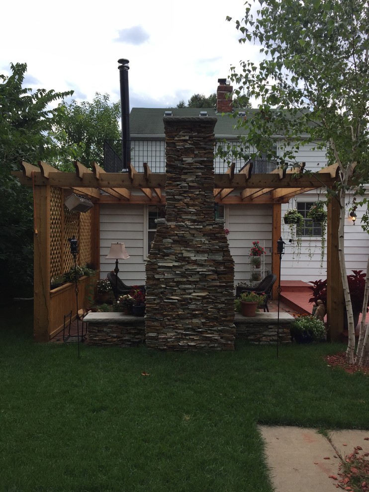 Aménagement d'une petite terrasse arrière avec un foyer extérieur, des pavés en brique et une pergola.