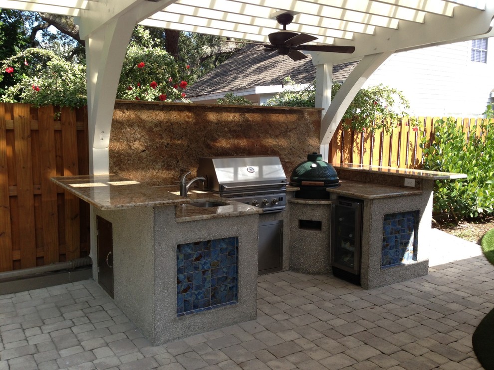 Imagen de patio costero de tamaño medio en patio trasero con cocina exterior, adoquines de hormigón y pérgola