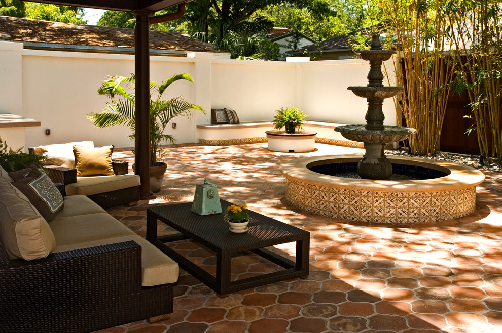 Esempio di un piccolo patio o portico mediterraneo dietro casa con pavimentazioni in cemento